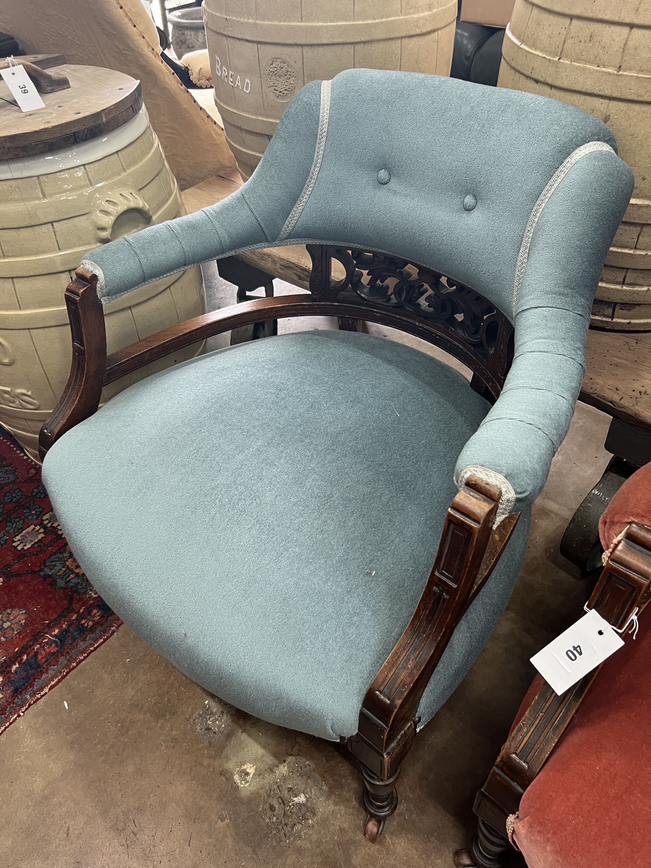A pair of late Victorian tub shaped open armchairs, upholstered, one in red, the other in blue, width 68cm, depth 58cm, height 72cm